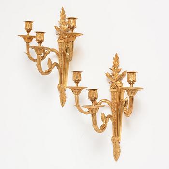 A pair of Louis XVI late 18th century gilt bronze three-light wall-lights.