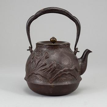 A Japanese iron tea pot with bronze cover, signed.