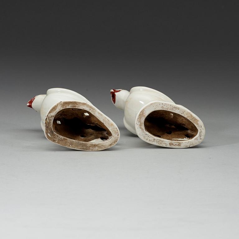 A pair of white and red glazed figures of parrots, late Qing dynasty.