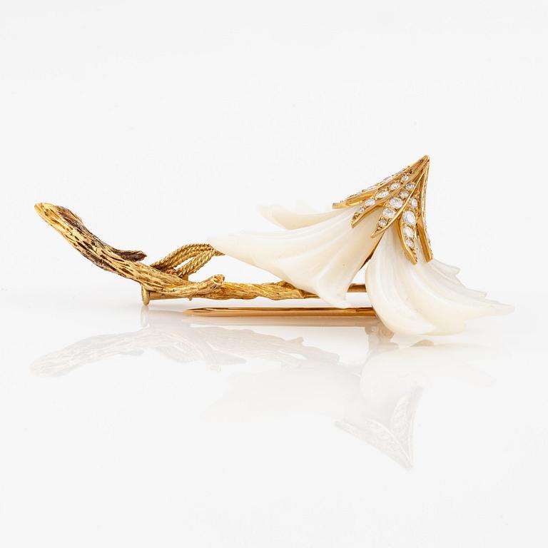 A Sterlé flower brooch in 18K gold and mother-of-pearl set with round brilliant-cut diamonds.