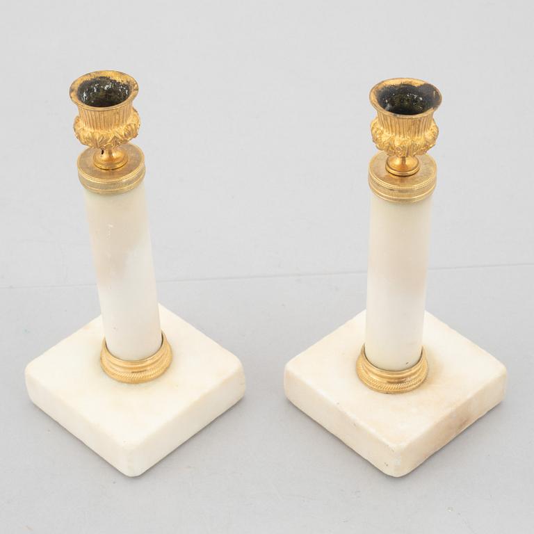 A pair of marble and gilt-bronze Louis XVI-style candelsticks, circa 1900.