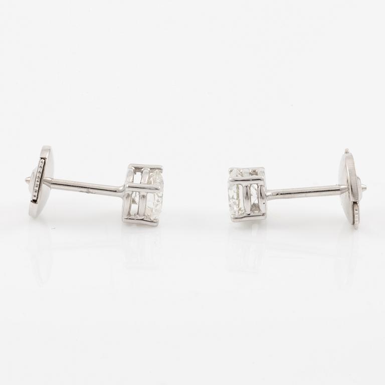 A pair of earrings in 18K white gold set with two round brilliant-cut diamonds.