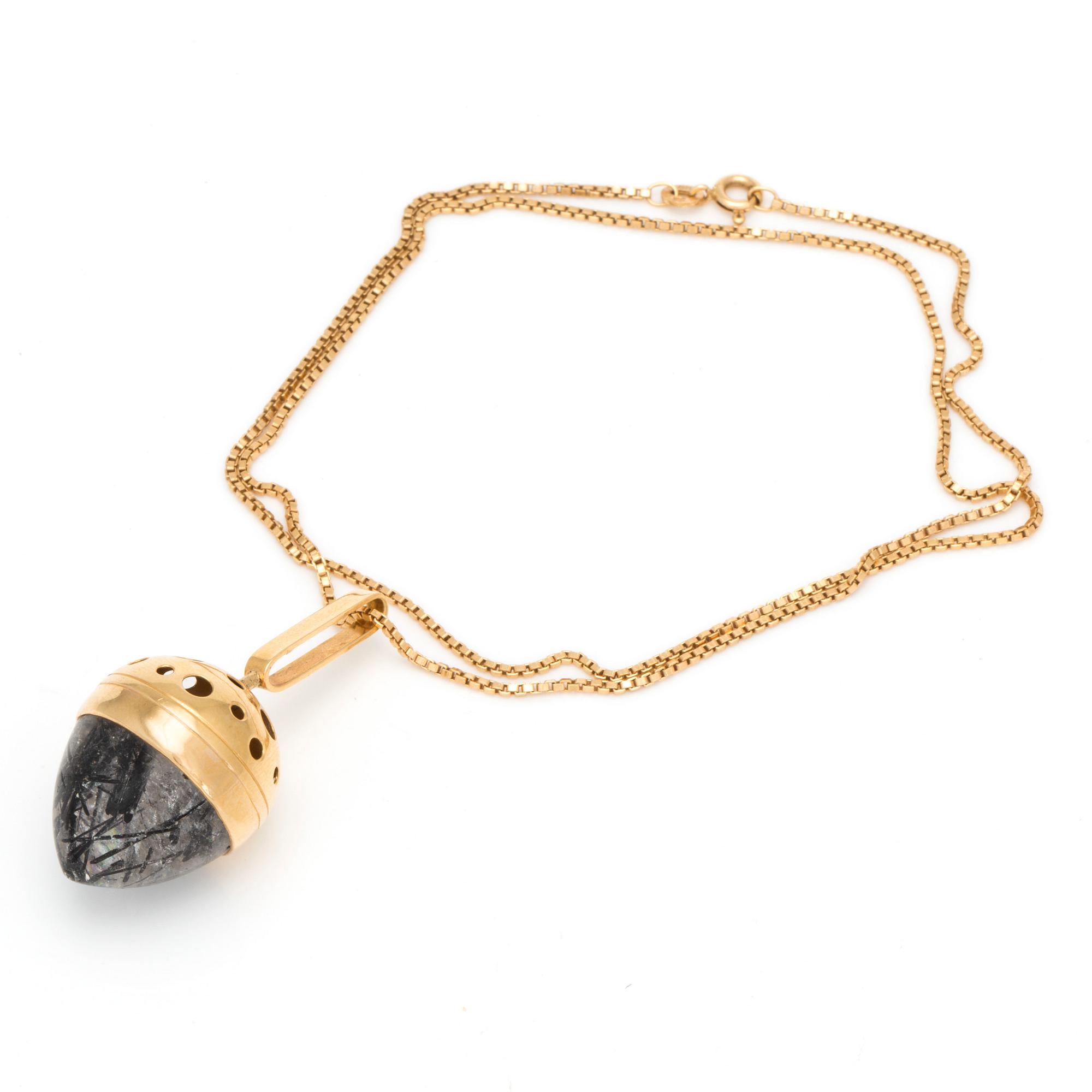 A 18K gold chain and pendant set with rutilated quartz.