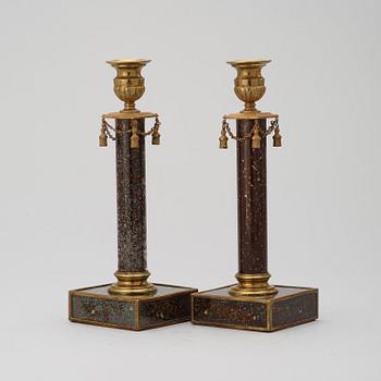 A pair of late Gustavian style 19th century porphyry imitation glass and brass candlesticks.