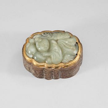 36. A partly gilded metal box with cover, mounted with a carved pale celadon nephrite plaque. Late Qing dynasty (1644-1912).