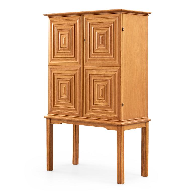 A Swedish Modern oak cabinet on stand attributed to Oscar Nilsson, 1940's.