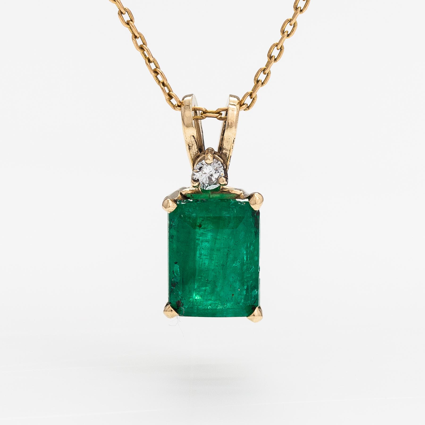 A 14K and 18K gold necklace with an ca. 2.22 ct emerald and a ca. 0.05 ct diamond.