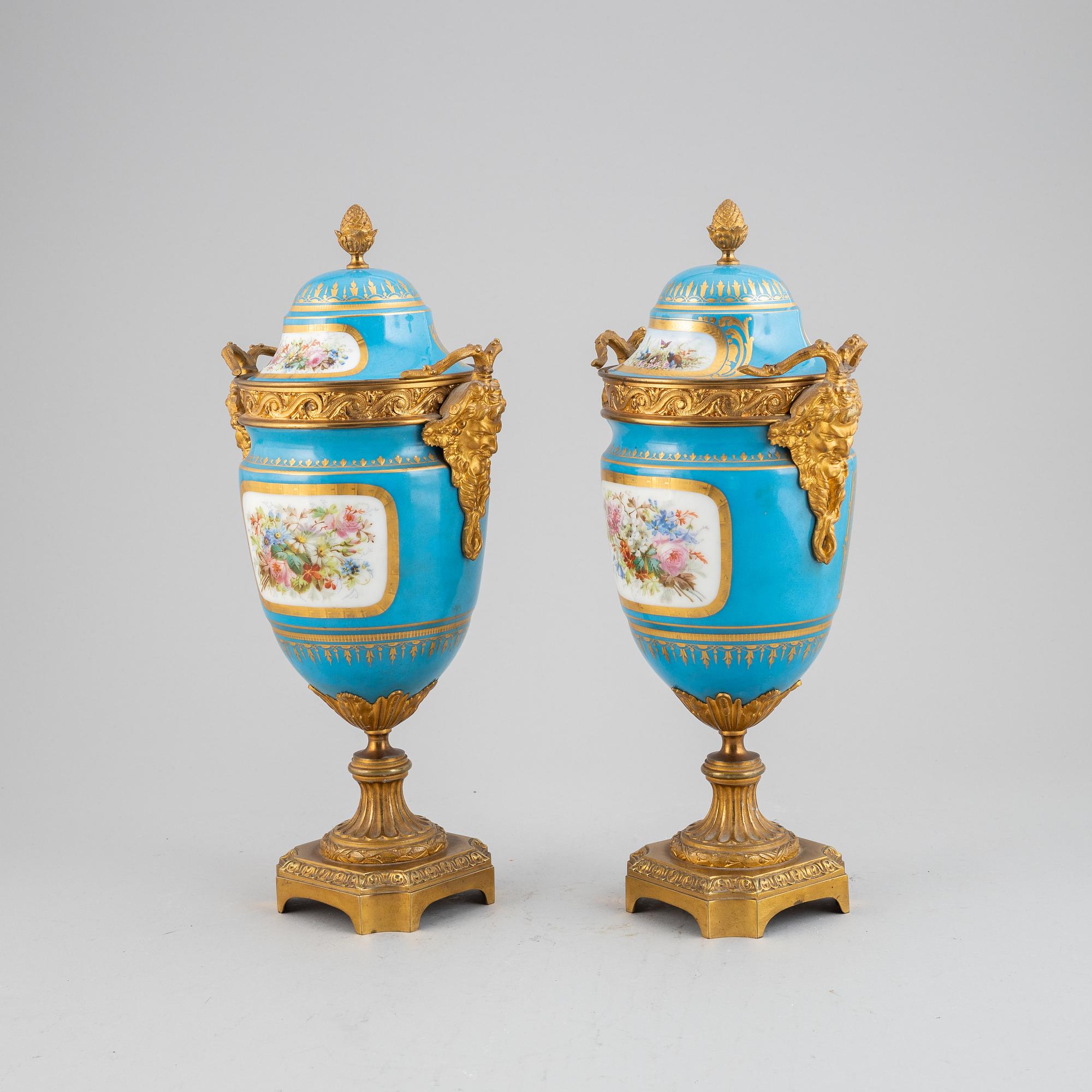 A pair of pordelain and gilt brass urns in teh style of Sevres, 20th Century.