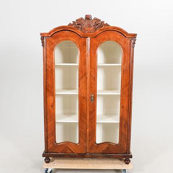 A walnut display cabinet around 1900.