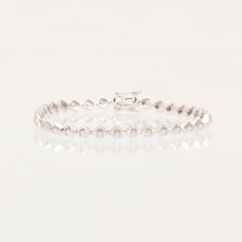 An 18K white gold tennis bracelet with round brilliant-cut diamonds.