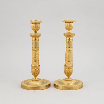 A pair of early 19th century Empire bronze candlesticks.