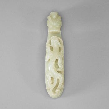 26. A pale celadon carved nephrite belt hook, Qing dynasty (1644-1912).