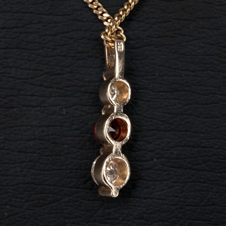 HÄNGE I KED, guld 14K, 2 diamanter tot. 0,34 ct, och en granat 0,32 ct. Vikt 4,1 g.