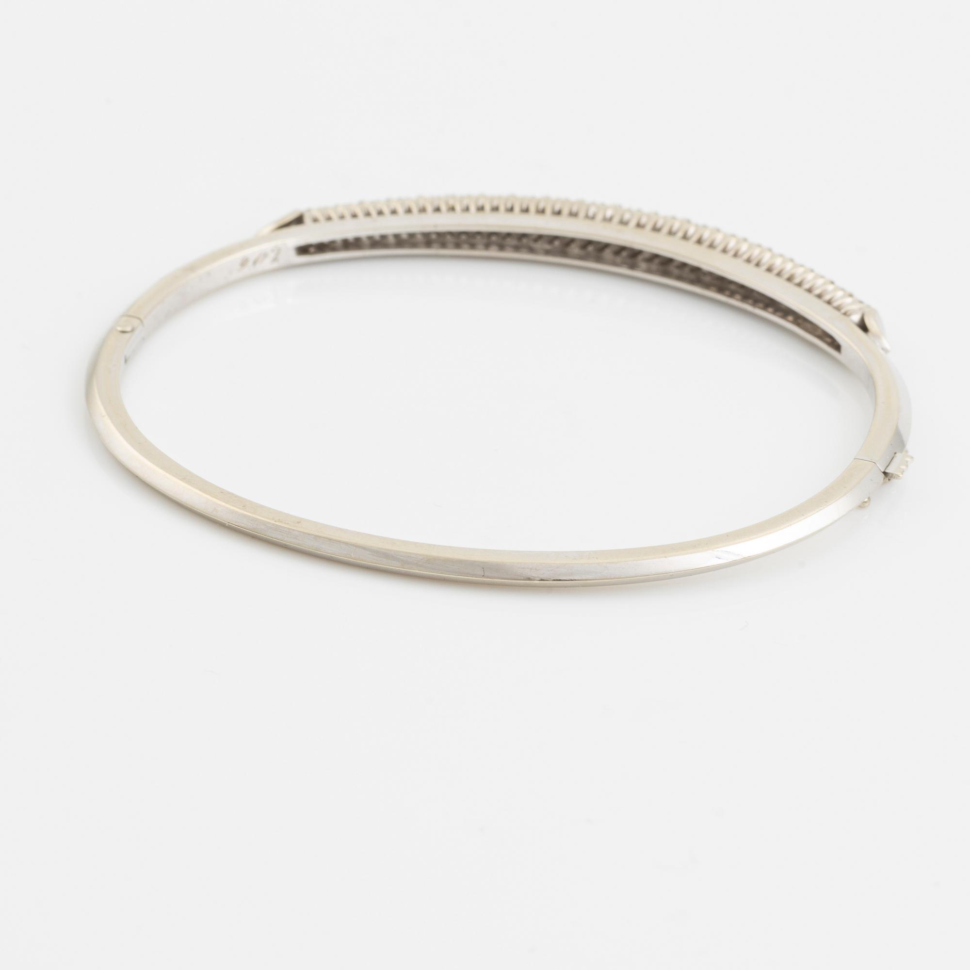 18K white gold bangle with round brilliant-cut diamonds.