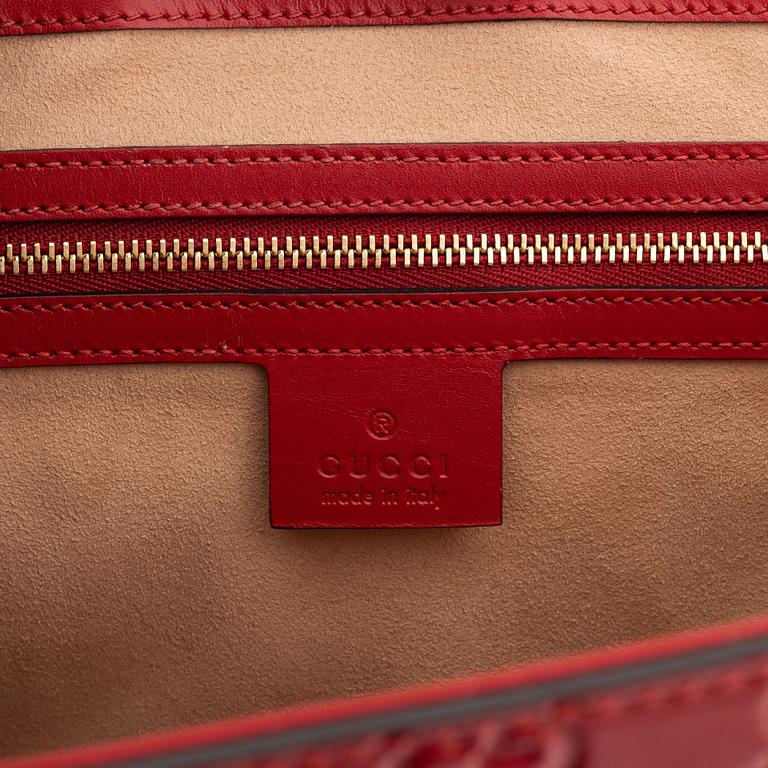 Gucci, a red, embossed leather handbag.