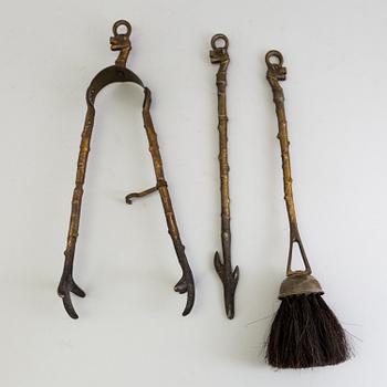 A set of three, early 20th century, bronze fire irons together with a stand, Nestor, England.