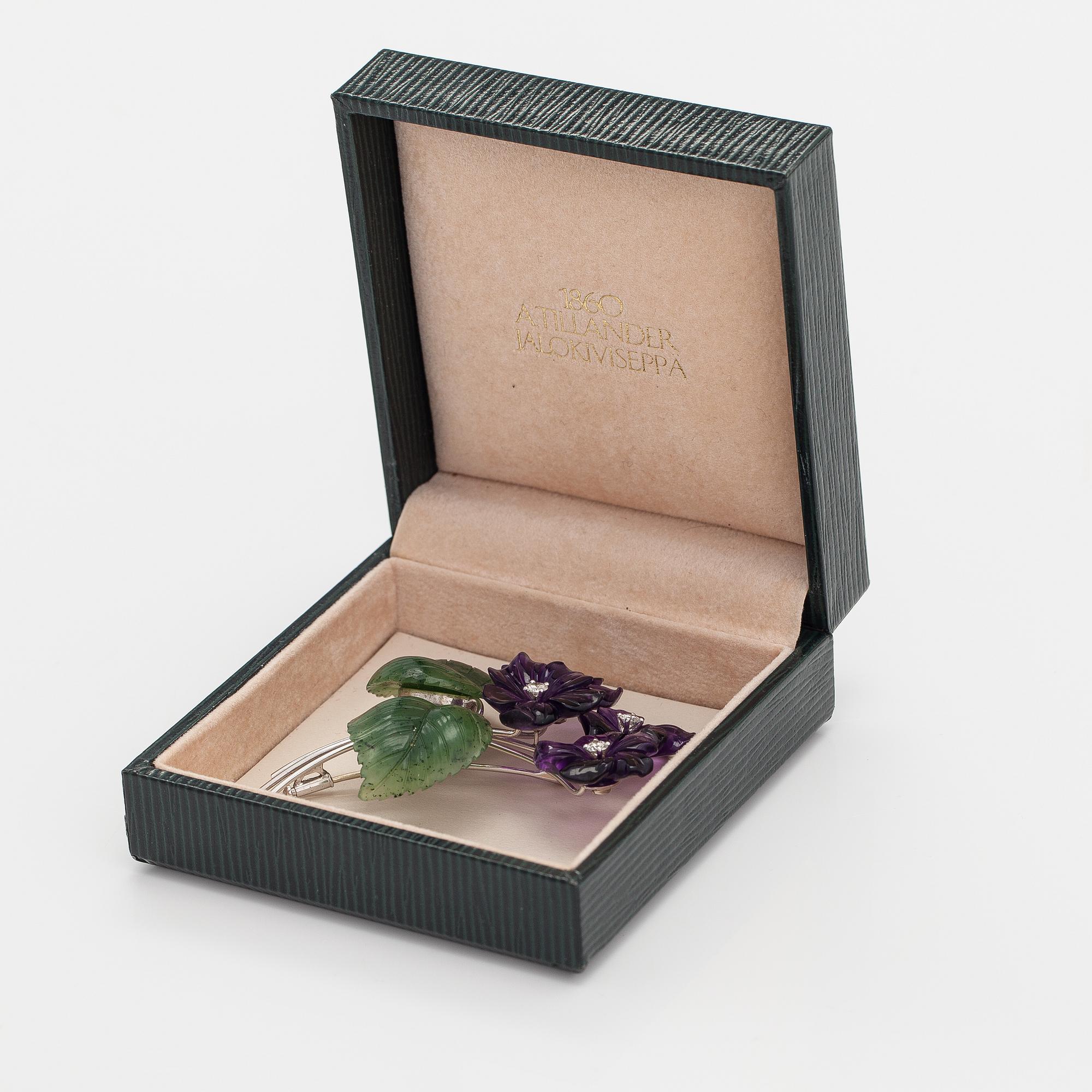 Rintaneula, 18K valkokultaa, veistettyjä ametisteja ja nefriitteja, timantteja n. 0.64 ct yht.