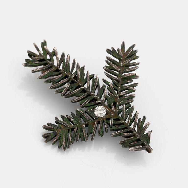 Brosch silver och emalj med en rund briljantslipad diamant.