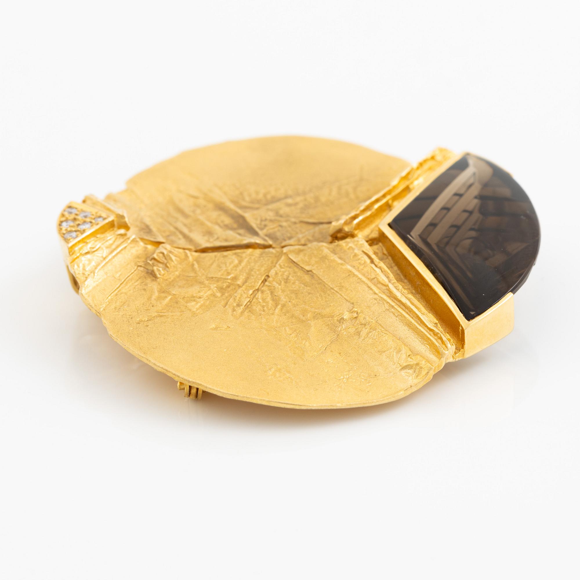 Brosch, 18K guld med fantasislipad rökkvarts och runda briljantslipade diamanter.