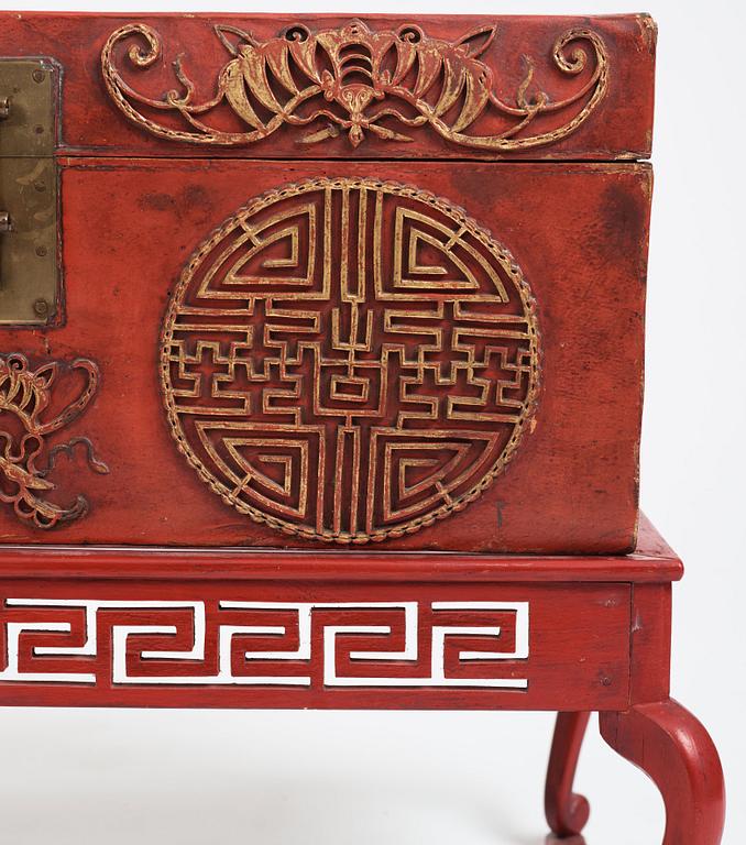 A red lacquered chest on a later stand, late Qing dynasty, 19th Century.