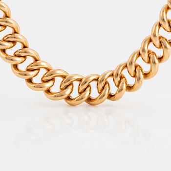 An 18K gold curb link bracelet.