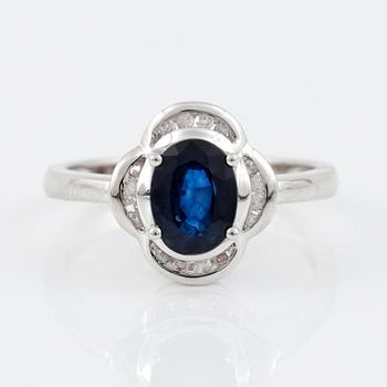 RING, 14K vitguld med ovalslipad safir tot ca 1,24 cts omgivs av 16 åttkantslipade diamanter. Vikt 3,47 g.