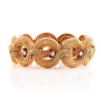 An 18K gold bracelet set with round brilliant-cut diamonds and rubies.