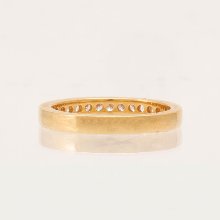 An 18K gold half-eternity ring set with round brilliant-cut diamonds.