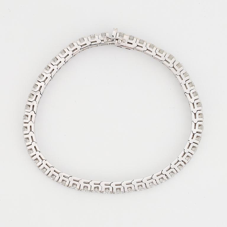 An 18K white gold tennisbraclet set with round brilliant-cut diamonds.