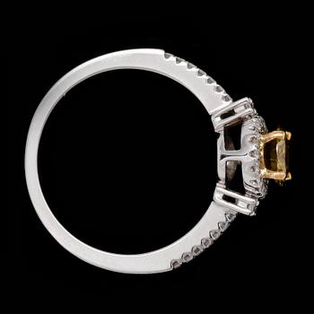 RING, briljantslipad gul diamant, ca 0.60 ct, samt mindre briljantslipade diamanter.