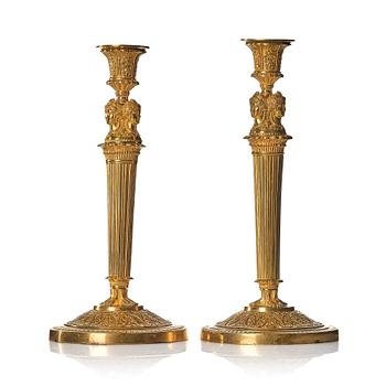 131. A pair of French Empire early 19th century gilt bronze candlesticks.