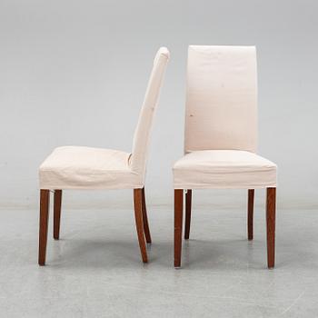 An stained oak dining table with eight chairs.