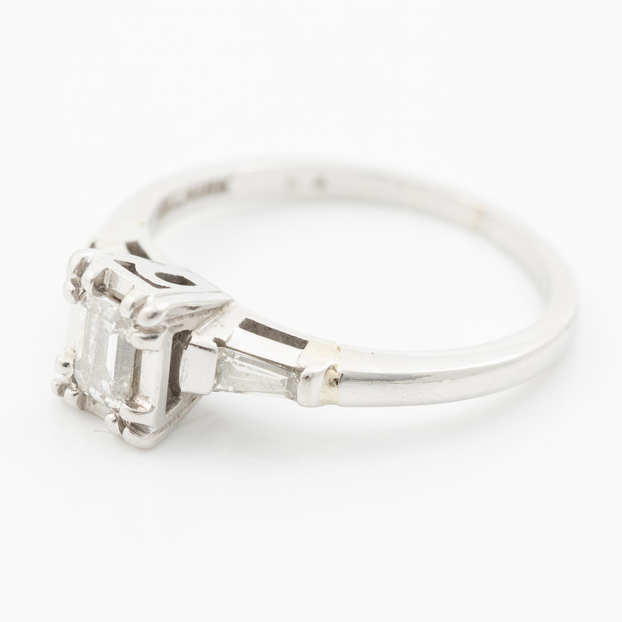 Platinum ring with an emerald-cut diamond and modified baguette-cut diamonds.