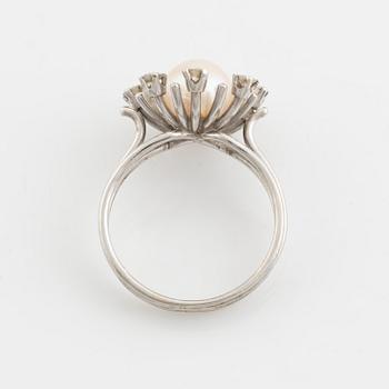 An 18K gold ring set with a cultured pearl and round brilliant-cut diamonds.