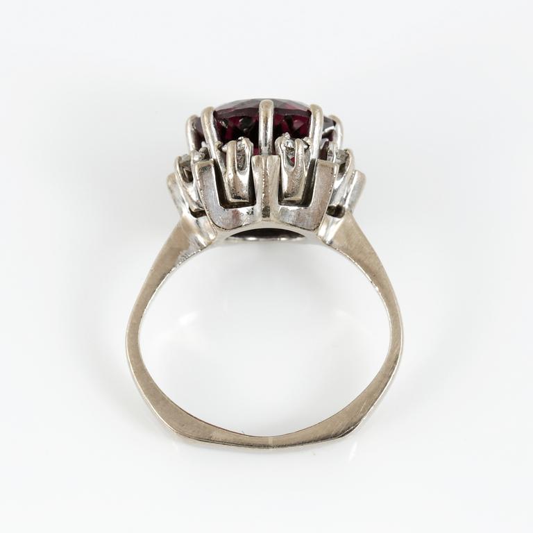 RING, 18K vitguld med fasetterad granat tot ca 3,68 cts omgiven av briljantslipade diamanter tot ca 0,4 ct. Vikt 6,91 g.