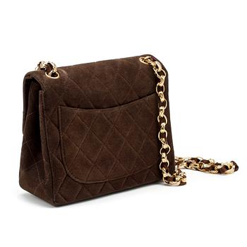 CHANEL, a brown suede quilted purse with shoulder strap.