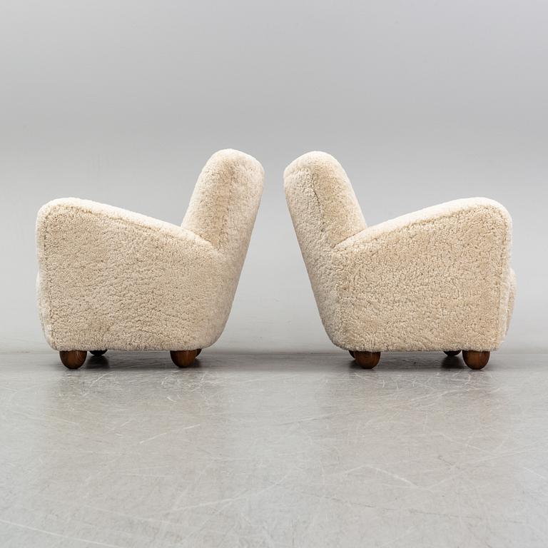 A pair of 1940's lounge chair with later sheepskin upholstery.