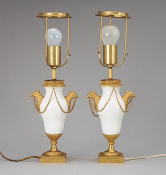 A pair of French circa 1800 gilt bronze and porcelain table lamps.