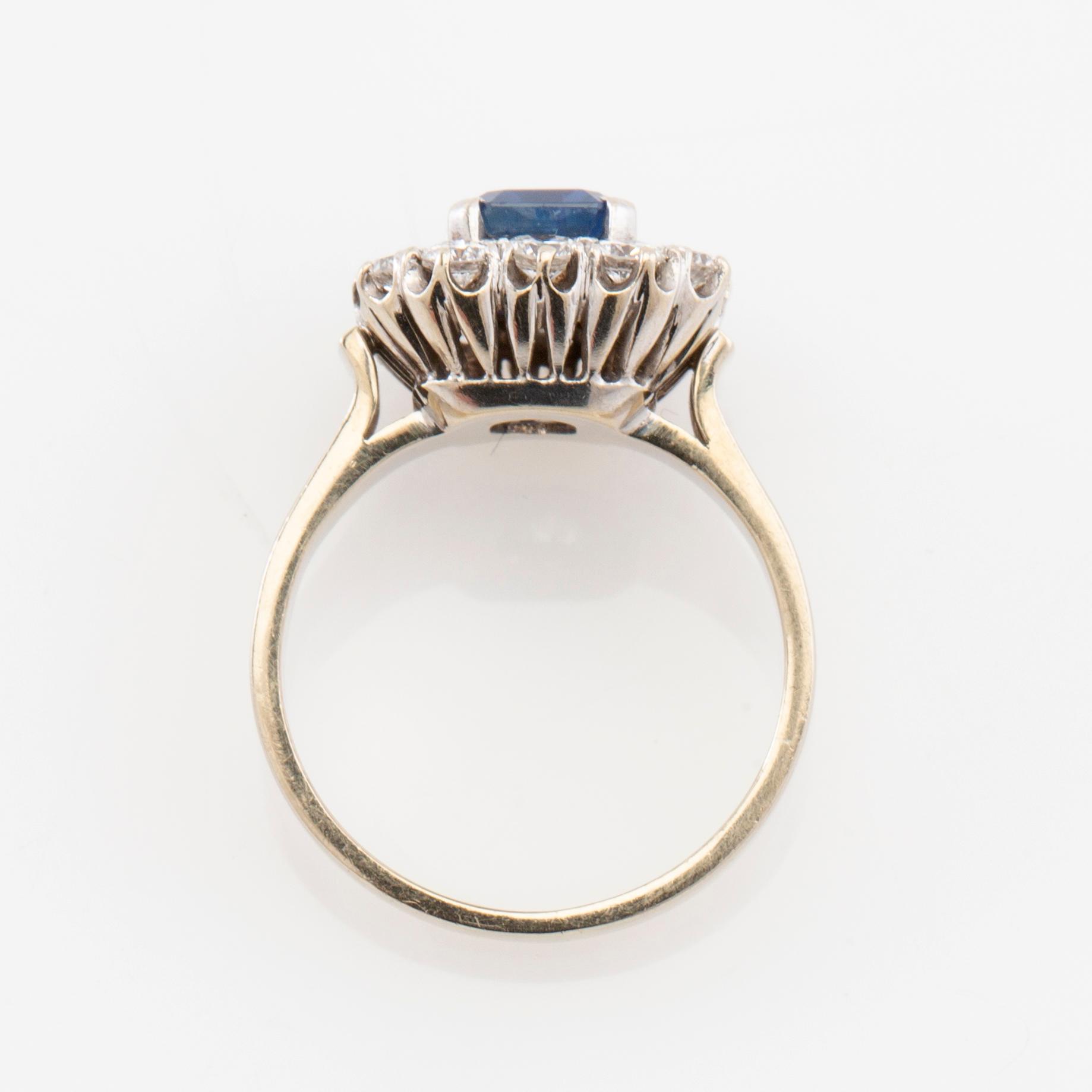 Ring in 18K white gold set with a step-cut sapphire and round brilliant-cut diamonds.