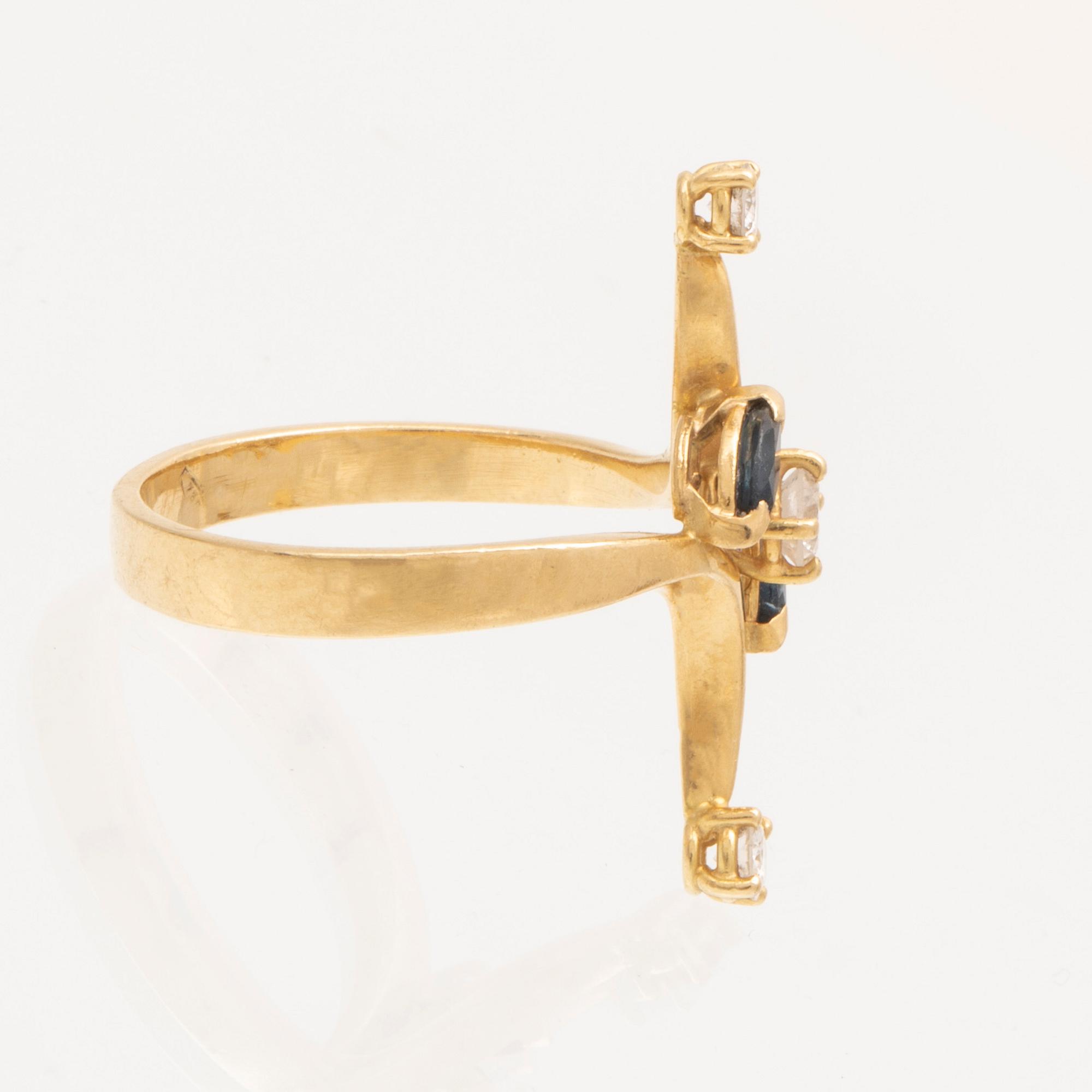 An 18K gold ring with marquise cut sapphires and round brilliant cut diamonds.