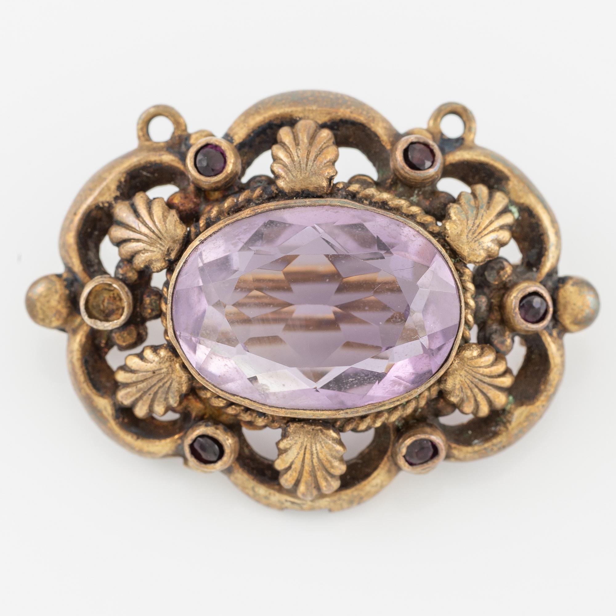 Brooch, gilded metal with a faceted amethyst.