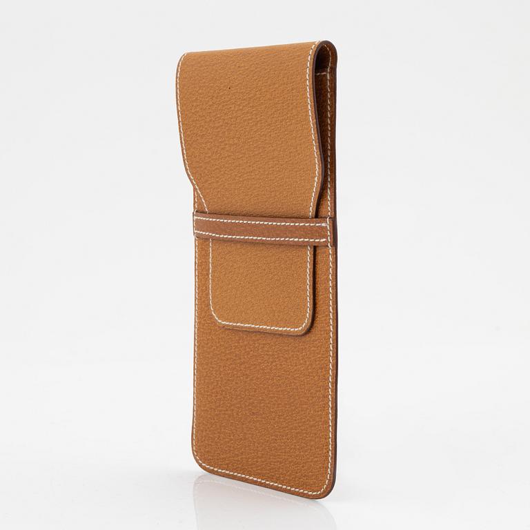 Hermès, a brown leather case for sunglasses.