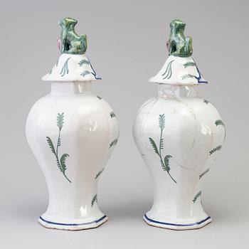 A pair of faience lidded urns, 18th/19th century.