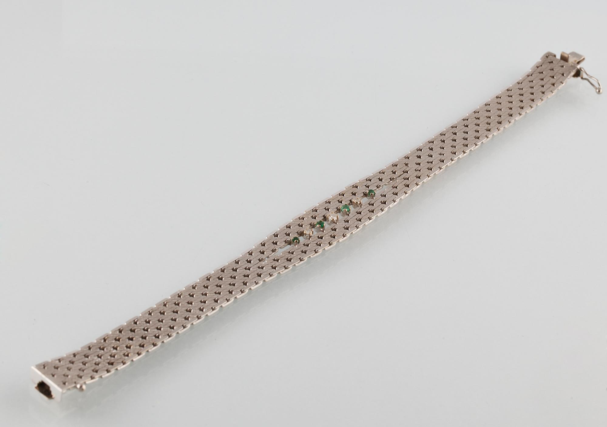 ARMBAND, 18K vitguld med en briljantslipad och 2 åttkantslipade diamanter samt 4 fasettslipade smaragder. Vikt 35,5 gram.