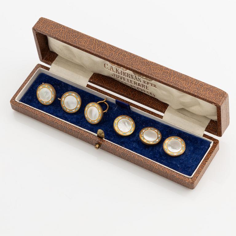 Sex stycken skjortknappar i gul metall med pärlemor och emalj.