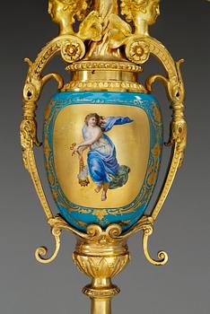 A pair of seven-light gilt bronze chandelabras with porcelain settings, 19th Century, presumably Russian.