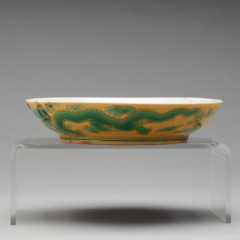 A yellow glazed dish with green five clawed dragons, Qing dynasty, Jiaqings seal mark in underglaze blue (1644-1912).