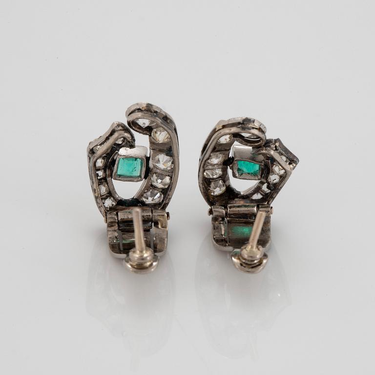 A pair of 18K white gold earrings set with faceted emeralds and old- and eight-cut diamonds.