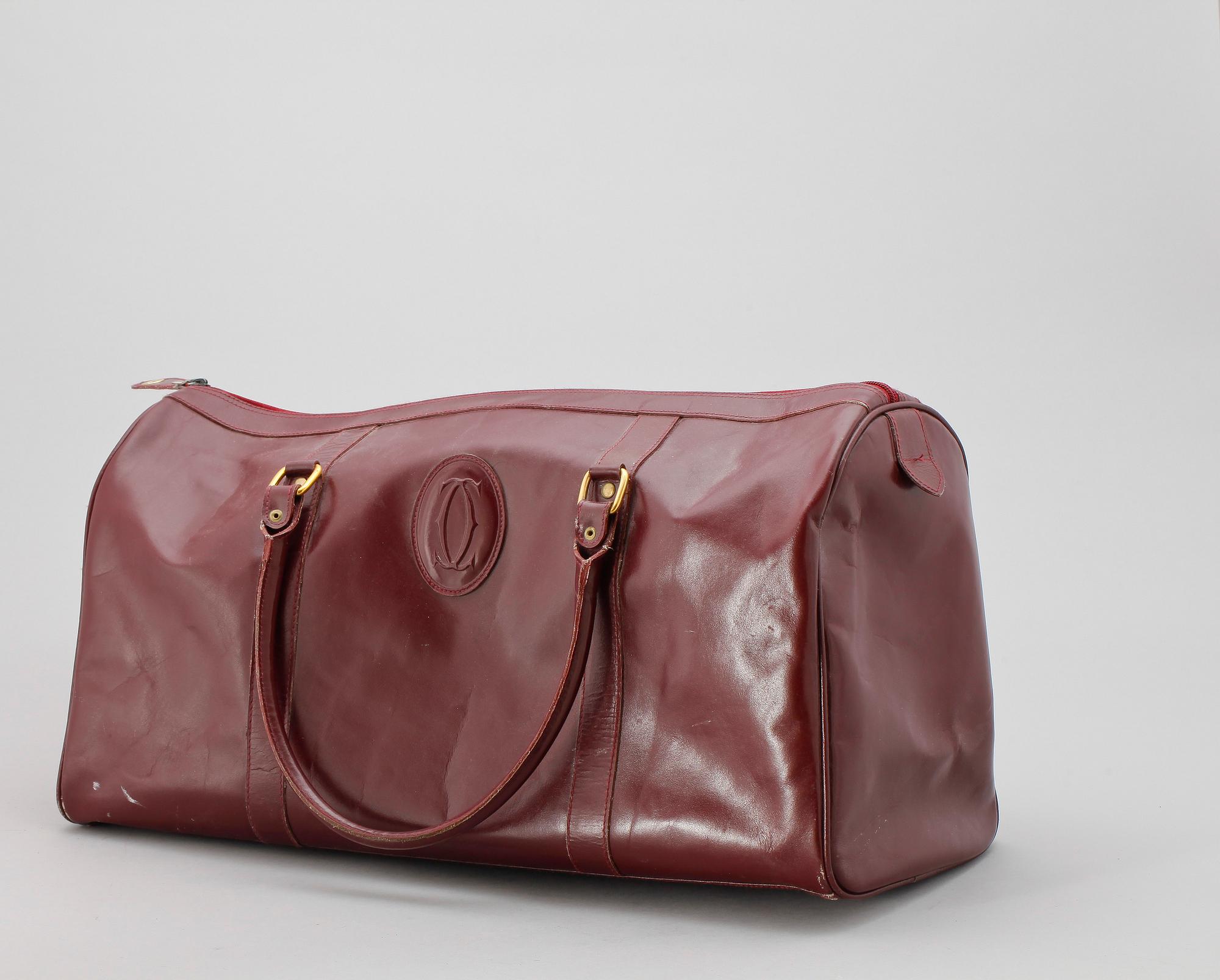 A bordeaux coloured leather weekendbag by Cartier.