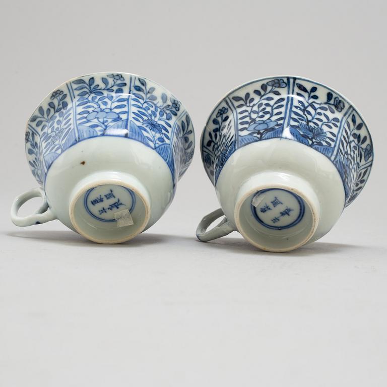 Four blue and white cups with dishes, Qing dynasty, circa 1900.